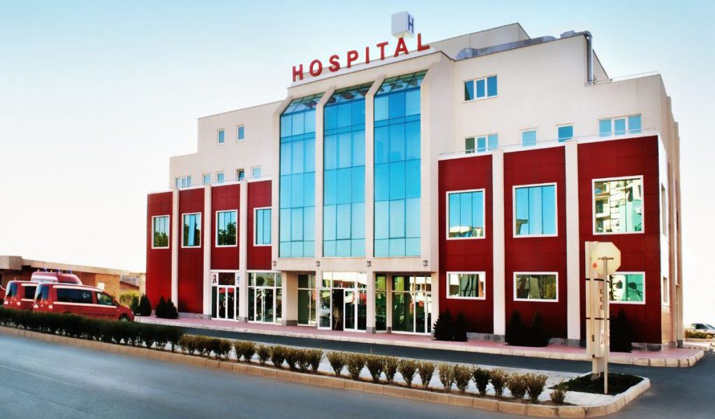 Exterior view of a modern hospital building with a sign labeled 'HOSPITAL'