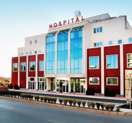 Exterior view of a modern hospital building with a sign labeled 'HOSPITAL'
